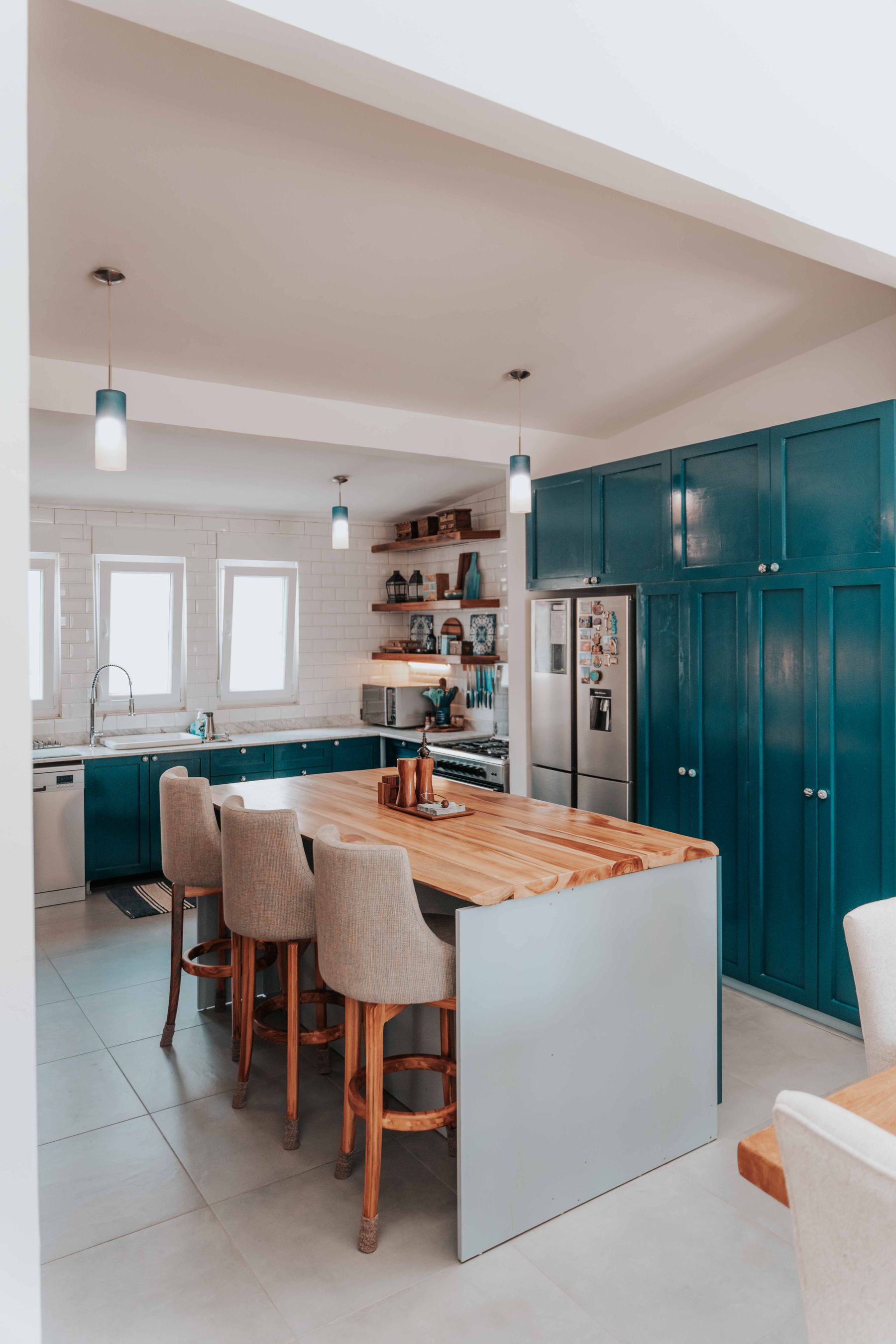 Illustratieve voorbeeldfoto van een blauwgroene keuken met geprofileerde kaderfronten en een houten kookeiland