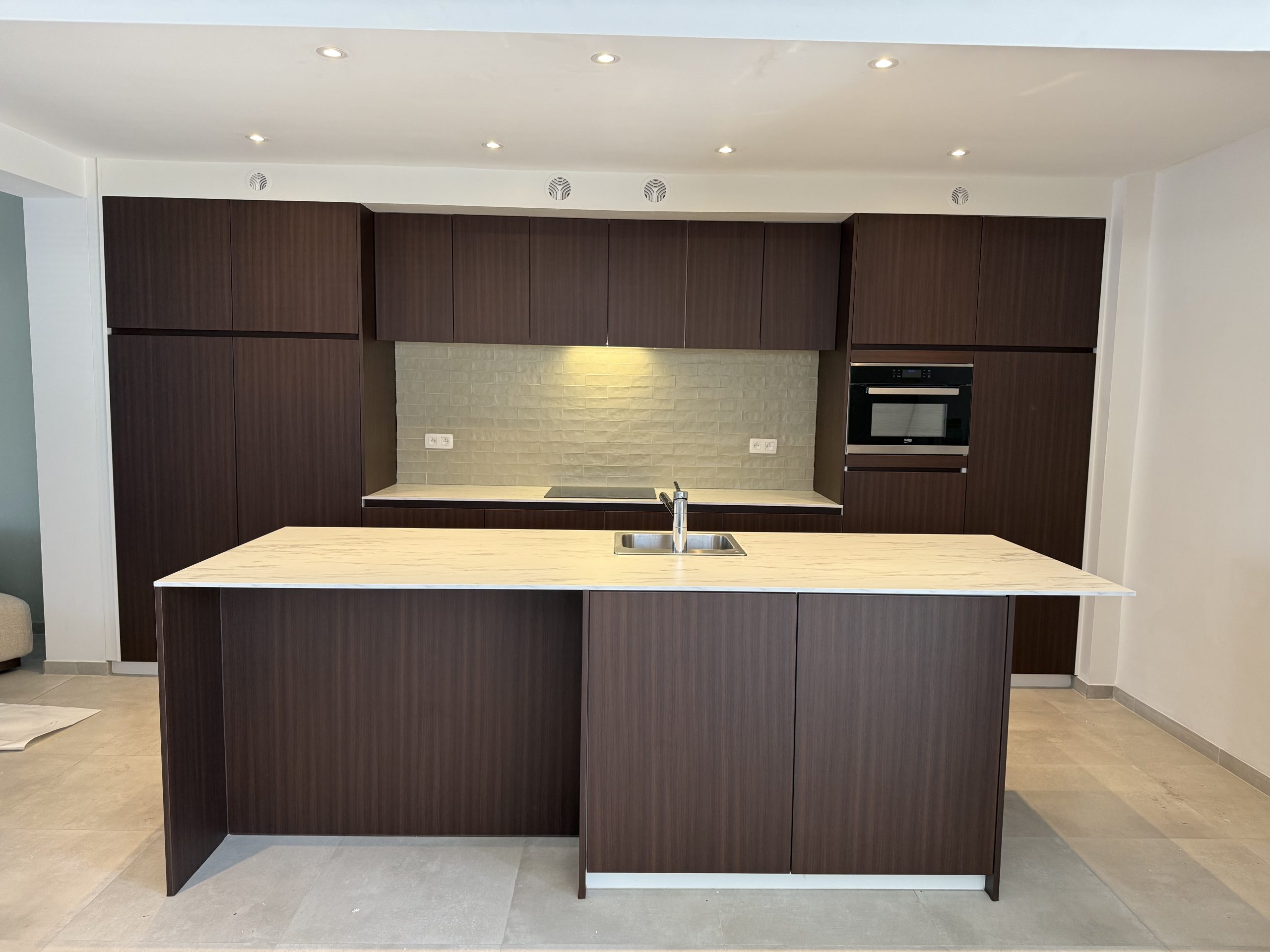 Dezelfde keuken na de transformatie met donkerbruine houtlook fronten