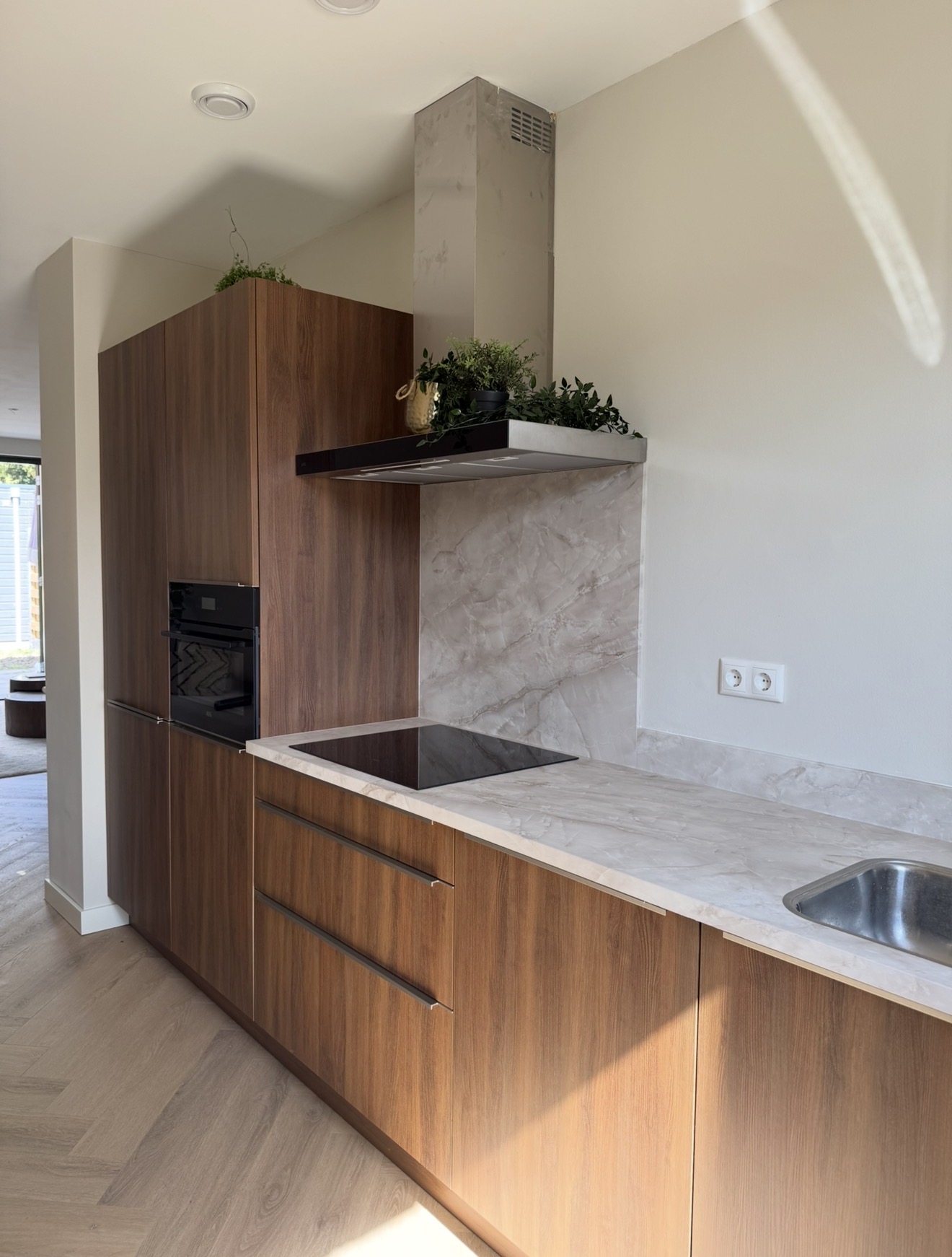 Keuken met warme houtlook fronten en een licht gemarmerd werkblad